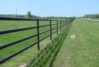 Multi-rail pipe fence along open pasture