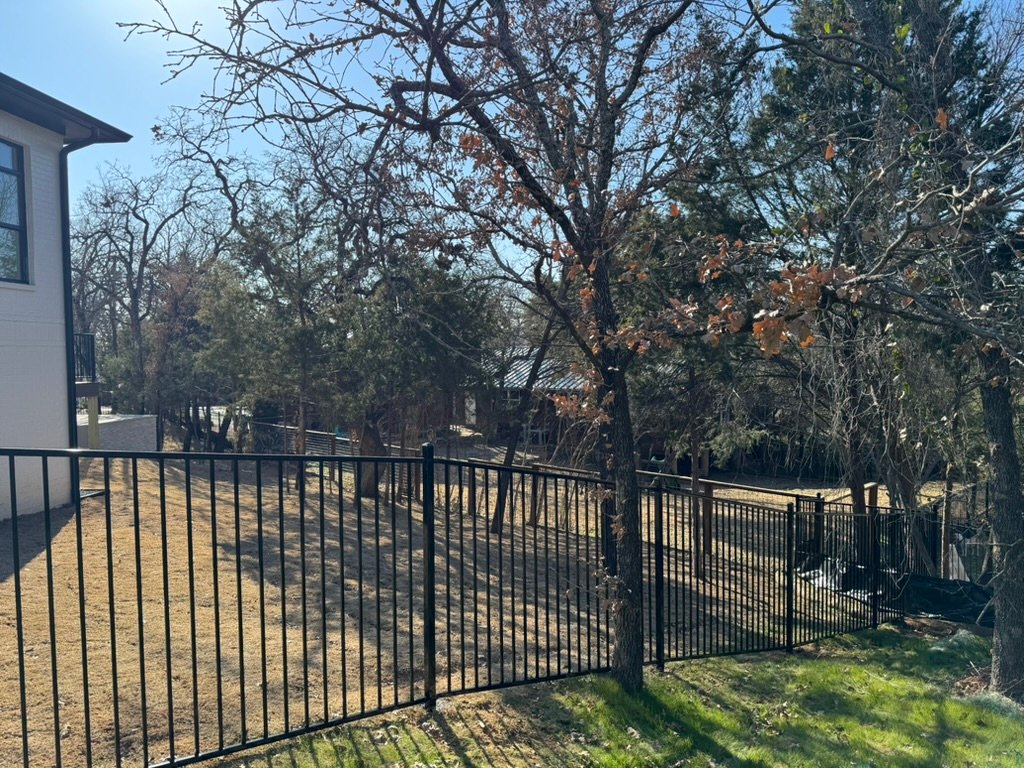 Iron fence installed on sloped terrain in North Texas